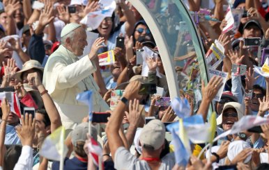 Pope Francis waves as he arrives to celebrate a mass at Huanchaco beach in Trujillo