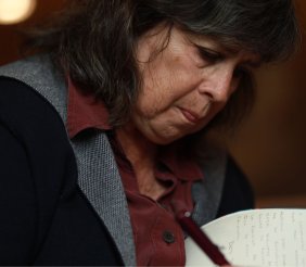 Una mujer de cabello negro firmando un libro