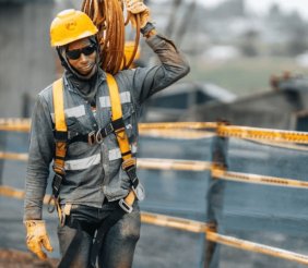 Un hombre con uniforme gris cargando cables