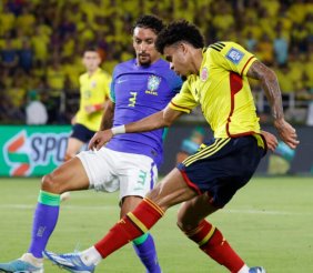 Dos jugadores disputando un balón: uno con uniforme amarillo y el otro azul