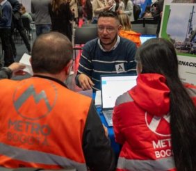 Una persona en una mesa, hablando con otras dos 