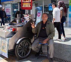 Un hombre al lado de un carro metálico