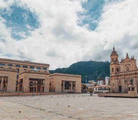 Una catedral al lado de un edificio de congreso en medio de una plaza