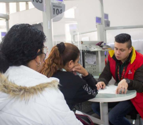 Dos mujeres sentadas al frente de un hombre con chaqueta roja