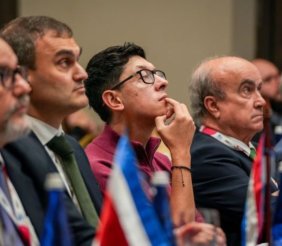 Cinco hombres sentados mirando fijamente hacia el frente
