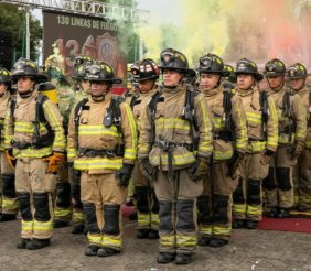 Una fila de hombres en marcha con uniformes de bombero