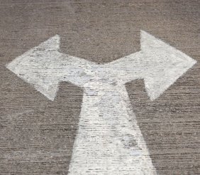 Un piso gris con un estampado blanco de una flecha señalando a la izquierda y a la derecha al mismo tiempo