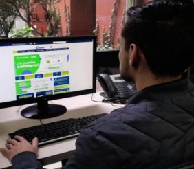 Un hombre sentado frente a un computador 