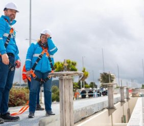 Un hombre y una mujer con chaquetas azules y cascos blancos