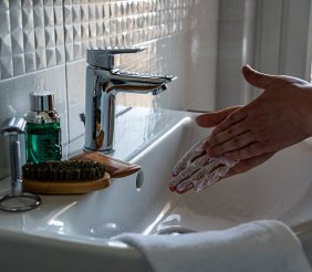 Grifo de agua y manos enjabonadas 
