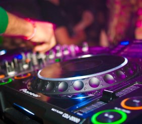 Una mano manipulando un mesa de mezclas de DJ