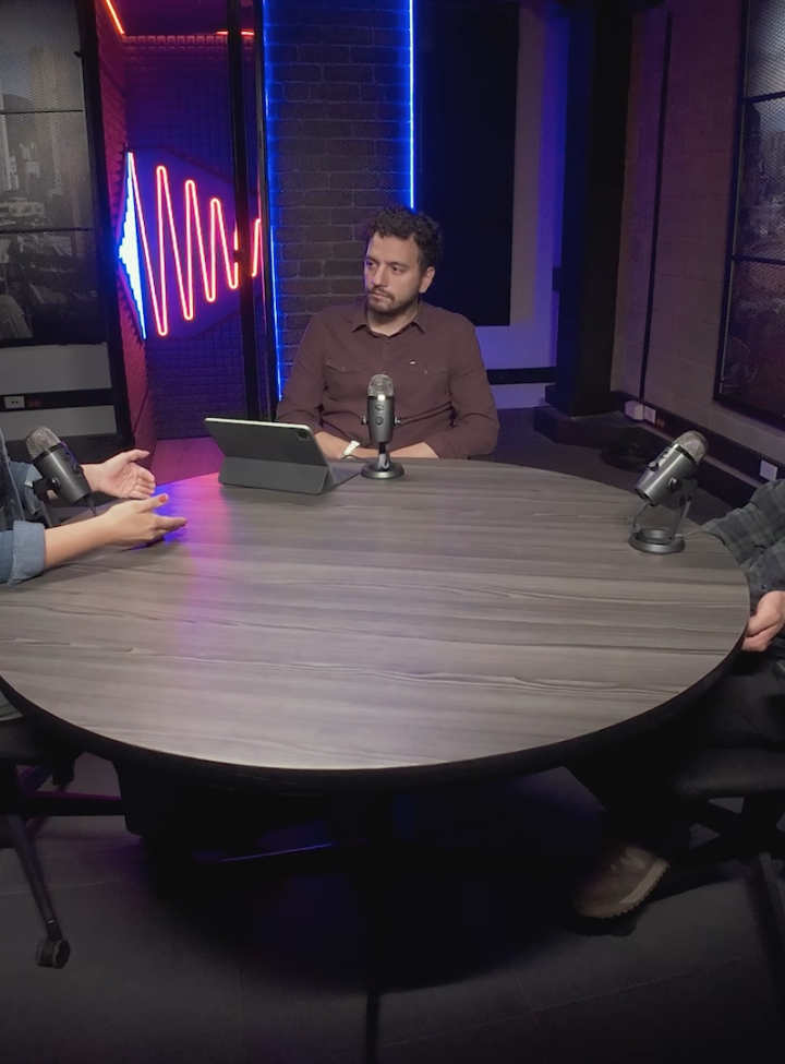 Tres personas hablando sentadas alrededor de una mesa 