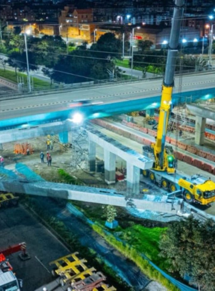 Un puente vehicular de concreto, rodeado de maquinaría de obra
