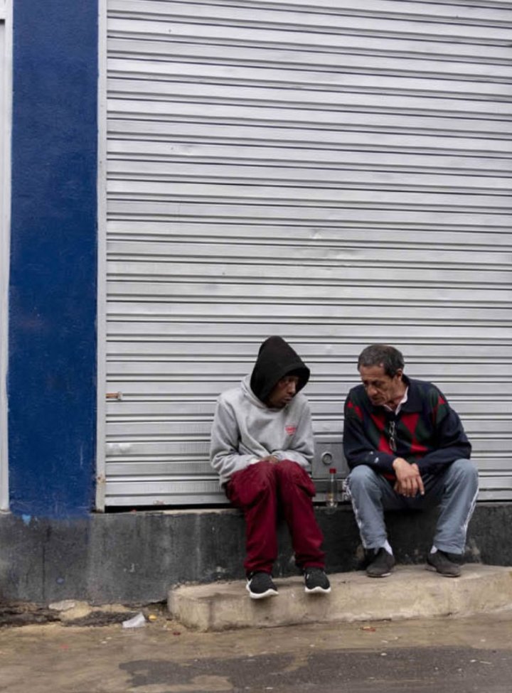 Dos hombres sentados en un andén