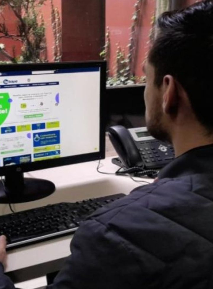 Un hombre sentado frente a un computador 